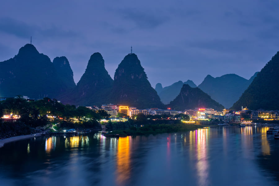 Paisaje de Yangshuo China de noche con reflejo del lago y luces nocturnas
